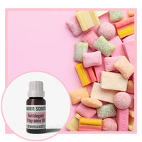 Colourful candy pieces on a pink background with a bottle of Seven Scents Bubblegum fragrance oil.