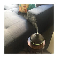 Lucy oil diffuser in dark wood creating warm atmosphere in home office