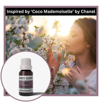 Woman smelling flowers with a bottle of Seven Scents Mika Fragrance Oil inset, inspired by Coco Mademoiselle by Chanel.