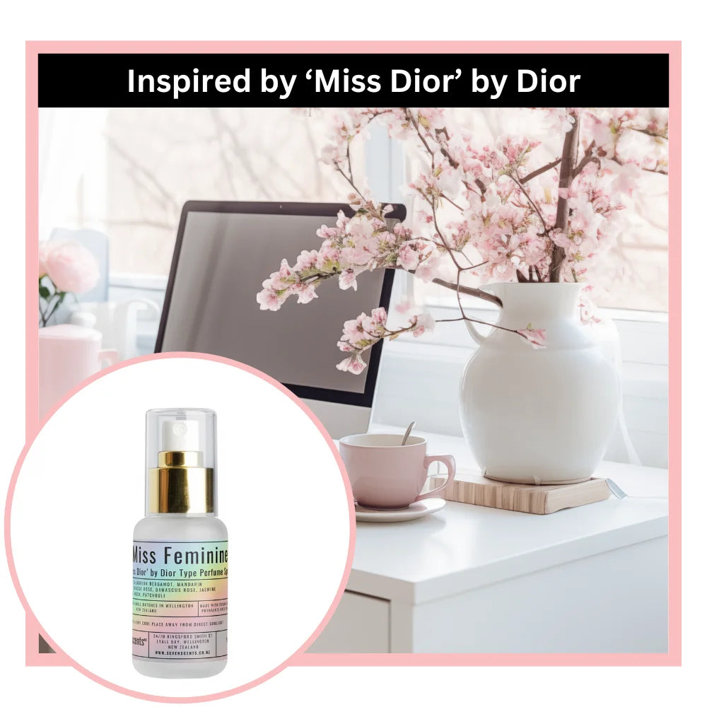 Miss feminine perfume spray inspired by 'Miss Dior' by Dior on a desk with flowers and a computer.