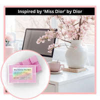 Miss feminine wax melts inspired by 'Miss Dior' by Dior on a desk with flowers and a computer.